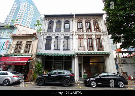 Alte Geschäftshäuser mit geparkten Autos und Geschäftsbetrieben in der Amoy Street in Singapurs Chinatown-Viertel. Stockfoto