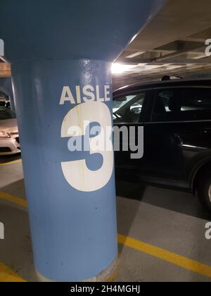 Parkgarage-Markierung mit einem Auto, das daneben geparkt ist Stockfoto