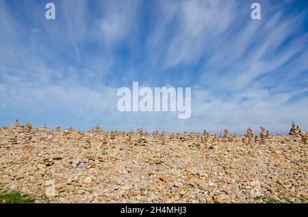 Cairns wurde von Besuchern von Lindisfarne Castle auf Holy Island vor der Küste von Northumberland im Nordosten Englands, Großbritannien, erbaut. Stockfoto