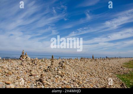 Cairns wurde von Besuchern von Lindisfarne Castle auf Holy Island vor der Küste von Northumberland im Nordosten Englands, Großbritannien, erbaut. Stockfoto