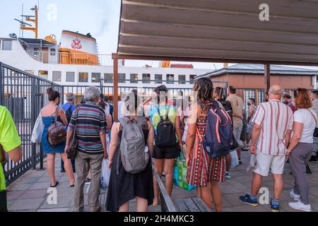 Kinaliada, Istanbul, Türkei - 07.30.2021: Eine Gruppe von Passagieren wartet an einem heißen sonnigen Sommertag auf das Vapur-Schiff im Fähranleger Stockfoto