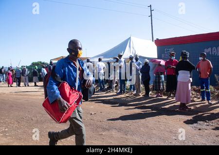 Pretoria, Südafrika. Januar 2021. Die südafrikanischen Kommunalwahlen 2021 finden am 1. November 2021 statt, um in jeder der neun Provinzen des Landes Räte für alle Bezirks-, Metropolregionen und Kommunen zu wählen. Es handelt sich um die sechste Kommunalwahl in Südafrika seit dem Ende der Apartheid im Jahr 1994, die alle fünf Jahre abgehalten wird. Ein Bewohner aus der informellen Siedlung Mooiplus, der die Straße gegenüber der Wahlstation überquert. November 2021. (Foto von Manash das/Sipa USA) Quelle: SIPA USA/Alamy Live News Stockfoto