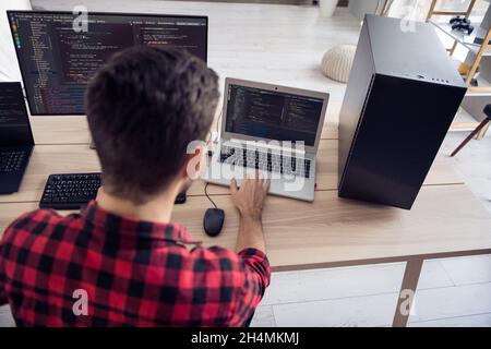 Hinten Wirbelsäule Ansicht Foto von jungen Mann Arbeit Computer schreiben Code-System Sicherheit drinnen im Büro Arbeitsplatz Stockfoto