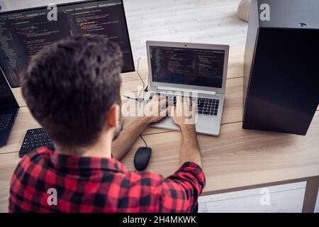 Hinten Wirbelsäule Ansicht Foto von jungen Mann sitzen Tisch Arbeit pc-Computer Geek Server Sicherheit drinnen im Büro Arbeitsplatz Stockfoto