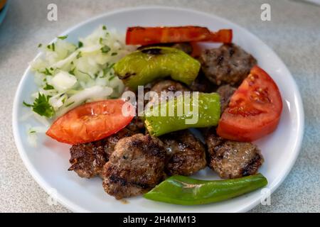 Izgara kofte, traditionelles türkisches Fleischgericht, gegrillt mit Gemüse auf dem Teller. Türkische Küche Foto Stockfoto