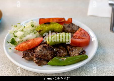 Izgara kofte, traditionelles türkisches Fleischgericht, gegrillt mit Gemüse auf dem Teller. Türkische Küche Foto Stockfoto
