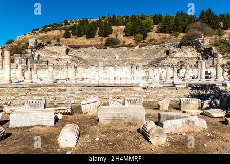 Ruinen der Oberen Agora bei Ephesus antike Stätte in der Türkei. Ansicht von Fragmenten von Säulen, mit der Heiligen Straße und Odeon im Hintergrund, auf einer Sonne Stockfoto