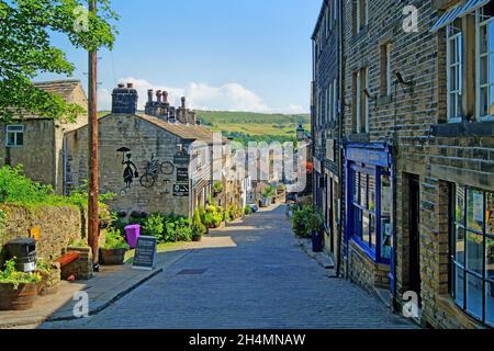 Großbritannien, West Yorkshire, Haworth, Geschäfte und Hütten an der Main Street Stockfoto