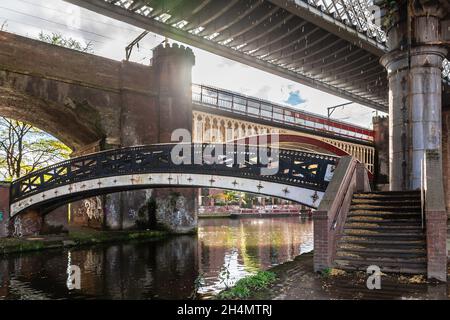 Der Bridgewater-Kanal von Castlefield mit neuen und alten Eisenbahnviadukten und Brücken aus alter (Gusseisen und Backstein) und moderner Stahlarchitektur. Deansgate, Stockfoto