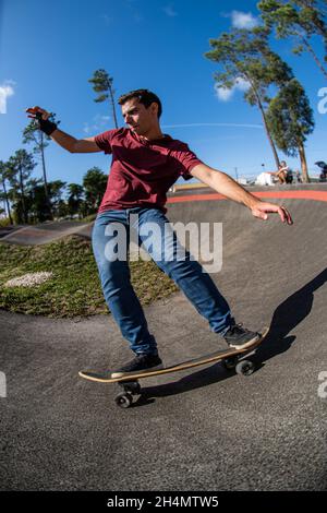 Skateboarder üben an einem sonnigen Tag auf einem Pump Track Park. Stockfoto