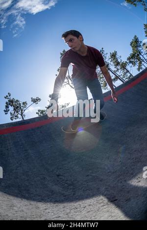 Skateboarder üben an einem sonnigen Tag auf einem Pump Track Park. Stockfoto