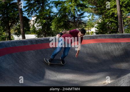 Skateboarder üben an einem sonnigen Tag auf einem Pump Track Park. Stockfoto