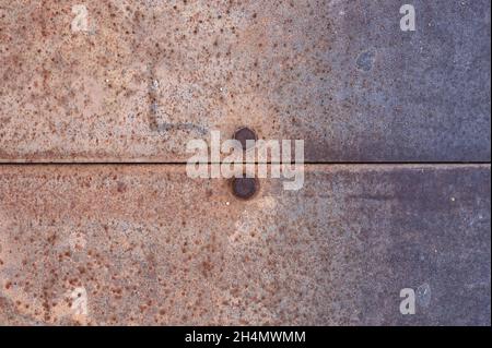 Detail von verrosteten Metallblechen, die durch Schrauben zusammengehalten werden Stockfoto