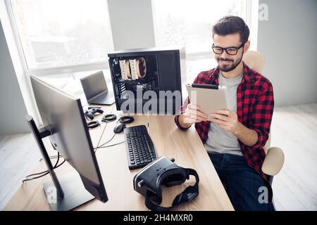 Portrait von attraktiven trendy fokussiert fröhlich smart Kerl lesen Tech-Bericht erstellen Programm am Büro Arbeitsplatz Arbeitsplatz Arbeitsplatz Arbeitsplatz innen Stockfoto