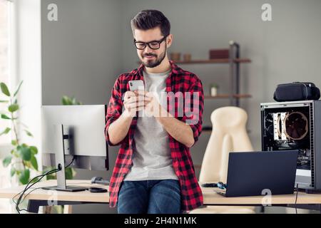 Porträt eines attraktiven fokussierten trendigen Kerl mit Gerät Gadget Browsing Web Bug Report Blog an Büroarbeitsplatz Workstation innen Stockfoto