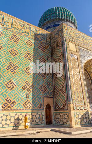 Die Gläubige kommt an der Mauer des Mausoleums von Khoja Ahmed Yasawi (14. Jahrhundert) vorbei und berührt sie. Hauptattraktion für muslime und Touristen in Turkistan Stockfoto