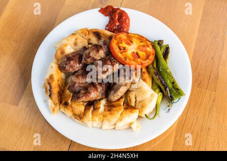 Akhisar, Manisa, Türkei – 9. November 2020. Traditionelle kofte Fleischbällchen auf Brot im original Kofteci Ramiz Restaurant Shop in Akhisar, Türkei. Stockfoto