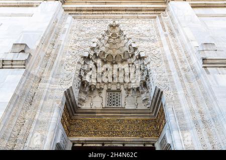 Bursa, Türkei – 10. November 2020. Die große Muqarnas-Nische über dem Eingang zur Grünen Moschee (Yesil Camii) in Bursa. Das Portal ist eingerahmt von fl Stockfoto