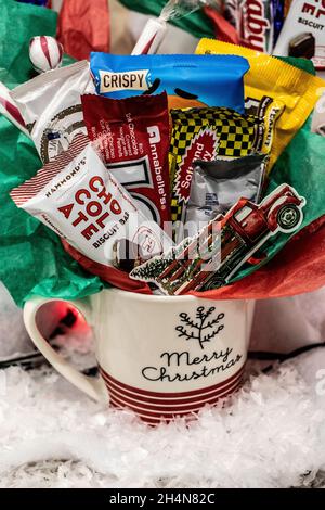 Eine fröhliche Weihnachtskaffeetasse gefüllt mit Süßigkeiten aus dem süßen Kismet Candy Store. Stockfoto