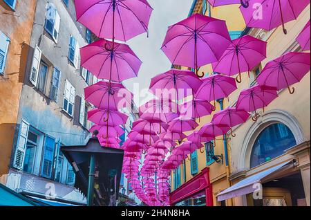 Ikonische rosa Regenschirme schmücken die Straßen der Stadt im historischen Zentrum von Grasse, Cote d'Azur, Frankreich Stockfoto