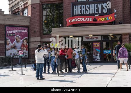 Hershey, Pennsylvania, 15. Oktober 2021: Gruppe von Touristen machen ein Gruppenfoto vor Hershey's Chocolate World Eingang Stockfoto