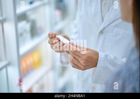 Apotheker Berater Hände halten kleinen Schlauch Stockfoto