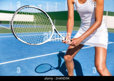 Tennisspielerin Frau bereit Spiel auf blauem Hartplatz halten Schläger in Position trägt weißen Kleid Rock. Weibliche Sportlerin Sport Mädchen im Sommer Stockfoto