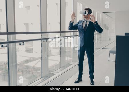 Successfu Business Professional in elegantem Anzug im Büro stehend und mit VR-Technologien bei der Arbeit Stockfoto
