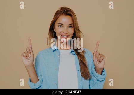 Charmantes Weibchen, das Glück auf beigem Hintergrund ausdrückt Stockfoto