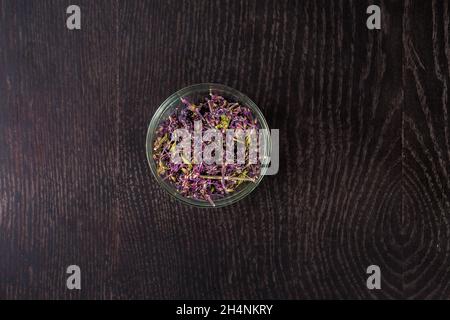 Getrocknete Blumen in einer Glasschüssel - Draufsicht. Auf schwarzem Hintergrund. Stockfoto