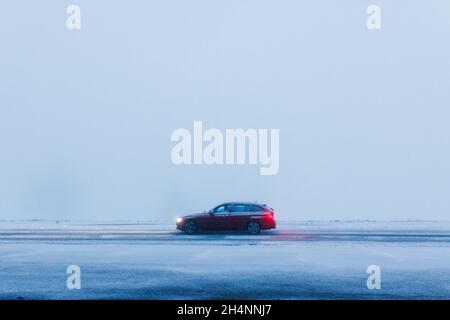 Freiburg Im Breisgau, Deutschland. November 2021. Ein Auto fährt in der Nähe des Gipfels des Schauinslands durch den frisch gefallenen Schnee, dahinter ist dichter Nebel zu sehen. Die Schneelinie im südlichen Schwarzwald ist in der Nacht unter 1000 Meter gefallen. Quelle: Philipp von Ditfurth/dpa/Alamy Live News Stockfoto