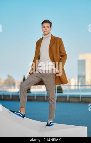 Frühling - Herbst Outfit. Street Fashion. Junger Mann in karierter Hose, Pullover und Wollmantel. Stockfoto