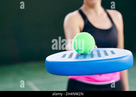 Athlet mit Padel-Schläger und Padel-Ball auf dem Platz, Nahaufnahme. Hochwertige Fotos Stockfoto