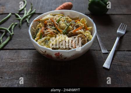 Verzehrfertige hakka-Nudeln mit Gemüse in einer Schüssel serviert. Nahaufnahme. Stockfoto