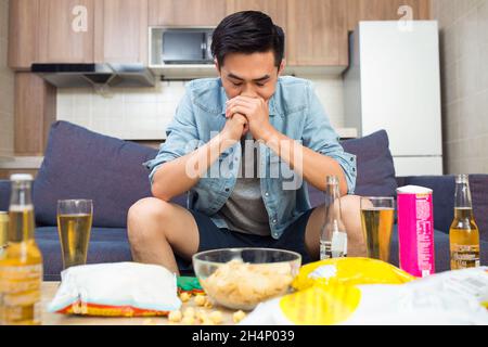 Junger Mann, der Sportspiele ansieht Stockfoto