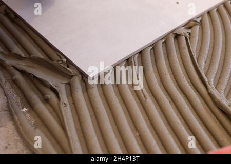 Keramik große Fliesen und Werkzeuge für Fliese auf dem Boden unvollendet Verlegung Bodenfliesen Bodenfliesen Installation Stockfoto