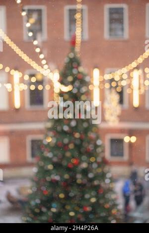 Weihnachtsbaum mit leuchtenden Lichtern. Altstadt mit Kiefern, die mit Girlanden geschmückt sind, verwackelte Bokeh-Aussicht Stockfoto