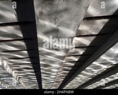 Die Donnington Bridge überquert die Themse stromaufwärts von Oxford. Hier sehen wir abstrakte Spiegelungen von gewelltem Wasser auf seiner Unterseite auf einem feinen Autu Stockfoto