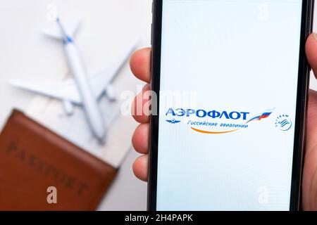 Aeroflot Airlines Firmenlogo auf dem Bildschirm des Mobiltelefons in der Hand des Mannes auf dem Hintergrund von Pass, Bordkarte und Flugzeug, 2021. September, San Stockfoto