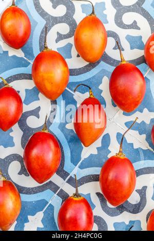 Frische Tamarillo-Früchte auf blauem Fliesenhintergrund. Bali, Indonesien. Stockfoto