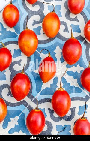 Frische Tamarillo-Früchte auf blauem Fliesenhintergrund. Bali, Indonesien. Stockfoto