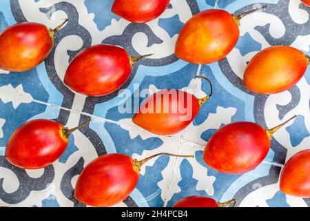 Frische Tamarillo-Früchte auf blauem Fliesenhintergrund. Bali, Indonesien. Stockfoto