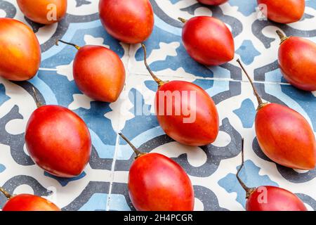 Frische Tamarillo-Früchte auf blauem Fliesenhintergrund. Bali, Indonesien. Stockfoto