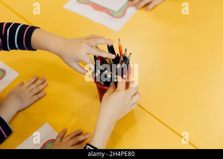 Kinderhände mit Zeichnungen und Buntstiften Stockfoto