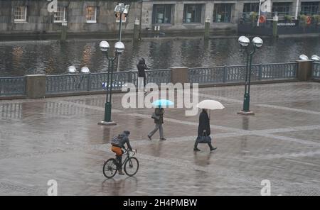 Hamburg, Deutschland. November 2021. Passanten schützen sich am Hamburger Rathausmarkt mit Regenschirmen vor Regen. Kredit: Marcus Brandt/dpa/Alamy Live Nachrichten Stockfoto