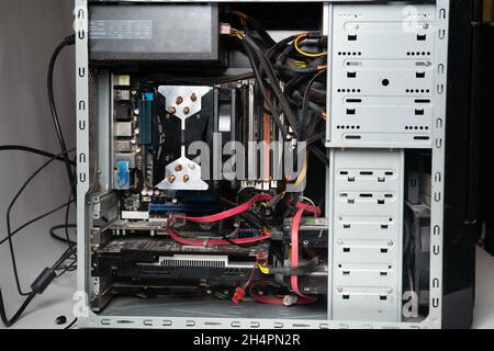 Die Systemeinheit des Computers ist ohne Abdeckung zerlegt. Viele alte Computerteile. Computer von innen. Stockfoto