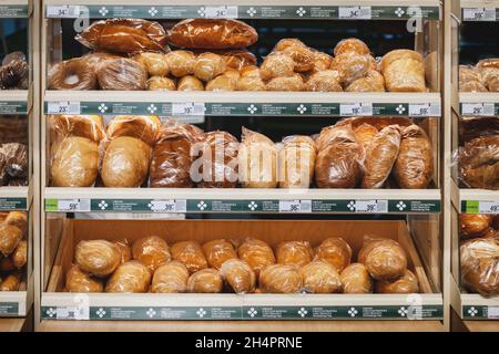 Verschiedene Arten von frischem Brot in Plastikverpackungen zum Verkauf in Supermarktregalen, Moskau, 28 Oct 2021 Stockfoto