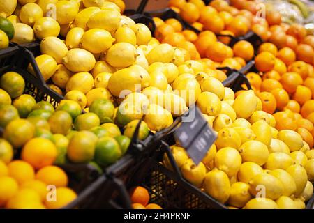 Zitrusfrüchte, die im Supermarkt verkauft werden, Zitronen, Orangen, Limetten in Kartons Stockfoto