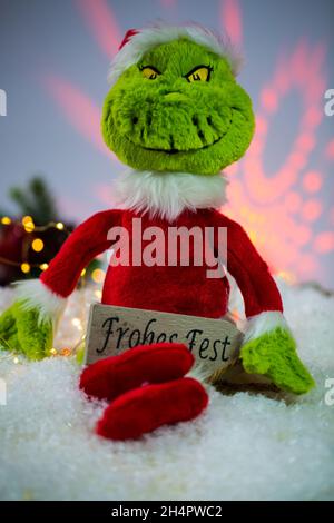 Grinch mit Geschenk, Frohe Weihnachten, lustige Postkarte Stockfoto