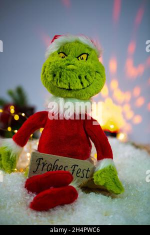 Grinch mit Geschenk, Frohe Weihnachten, lustige Postkarte Stockfoto